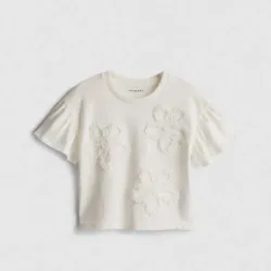 Blusa blanca con vuelos y flores