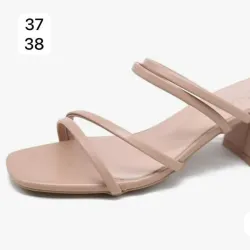 Sandalias de tacón medio en tono beige con diseño estilizado y funcional. 
