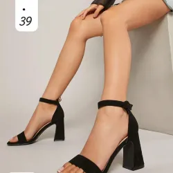 Sandalias negras de tacón alto con diseño minimalista y elegante.