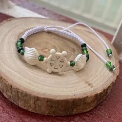 Pulsera con timón y conchas perladas