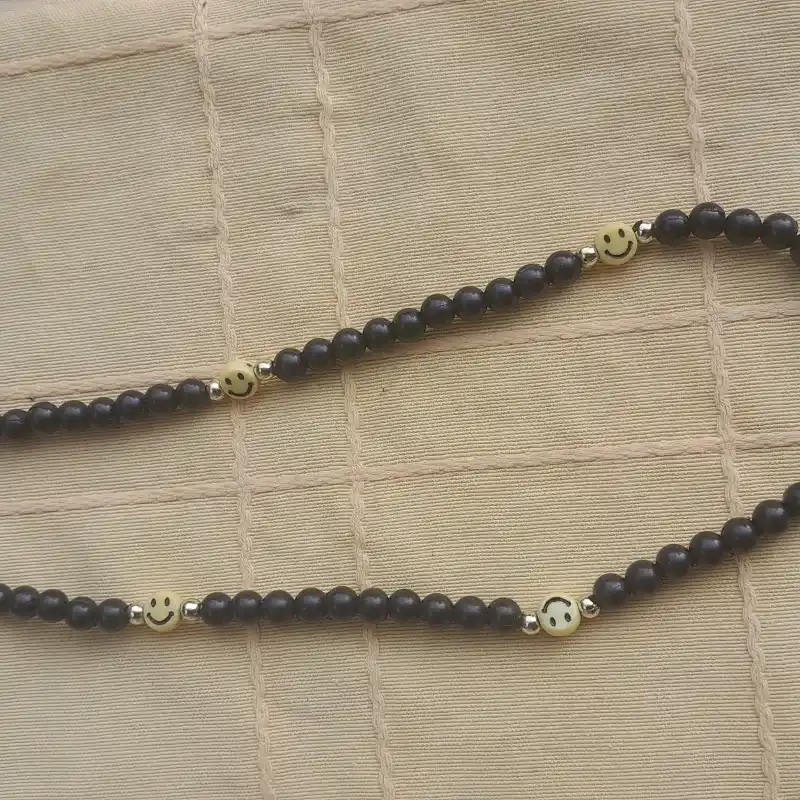 Collar de perlas negras con caritas 