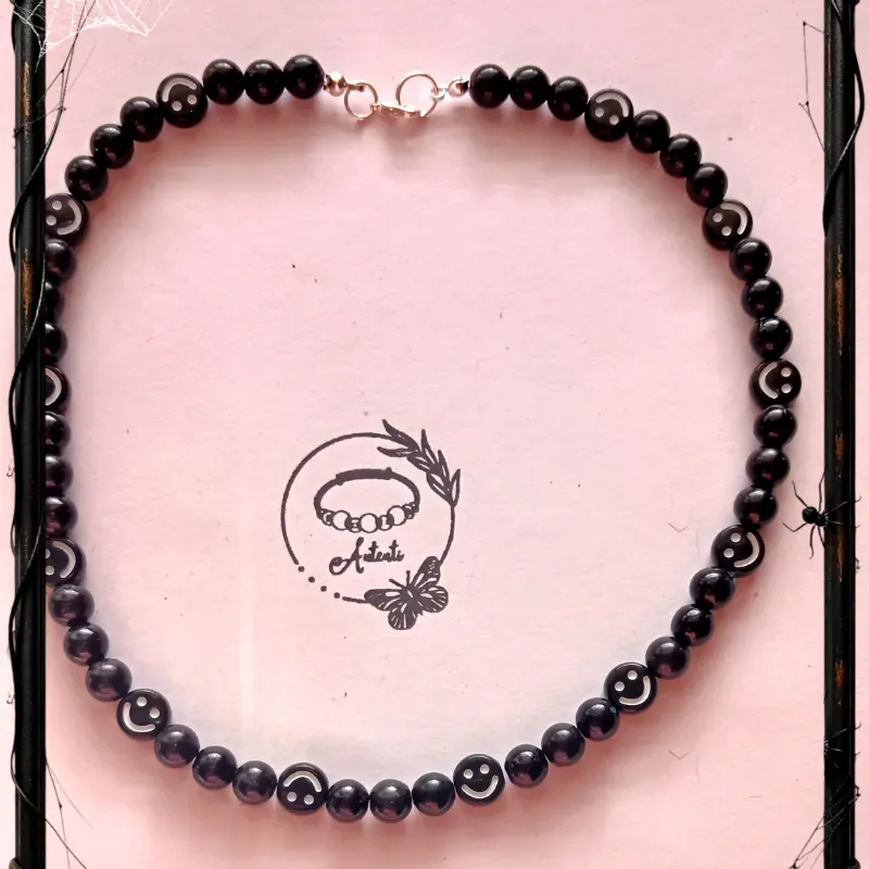 Collar de perlas negras con caritas 