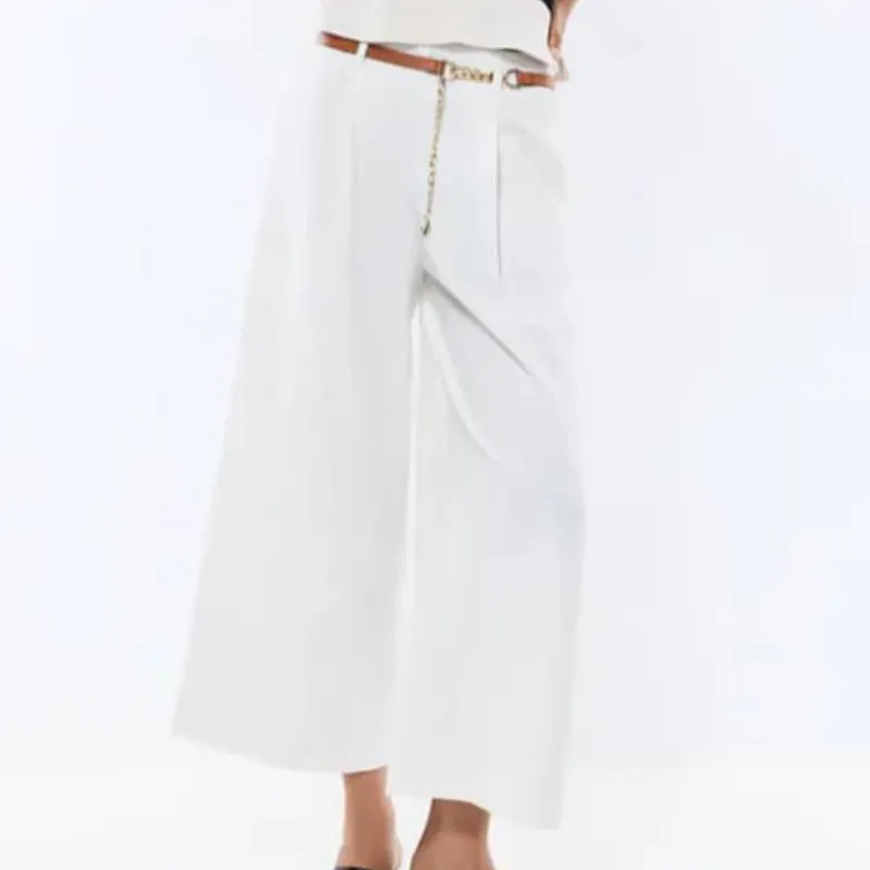 Pantalón blanco con cinto marrón con cadena