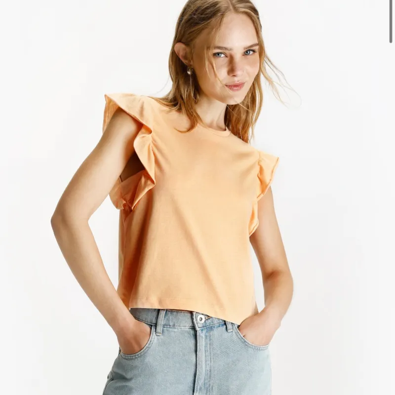 Top naranja claro vuelos en hombro