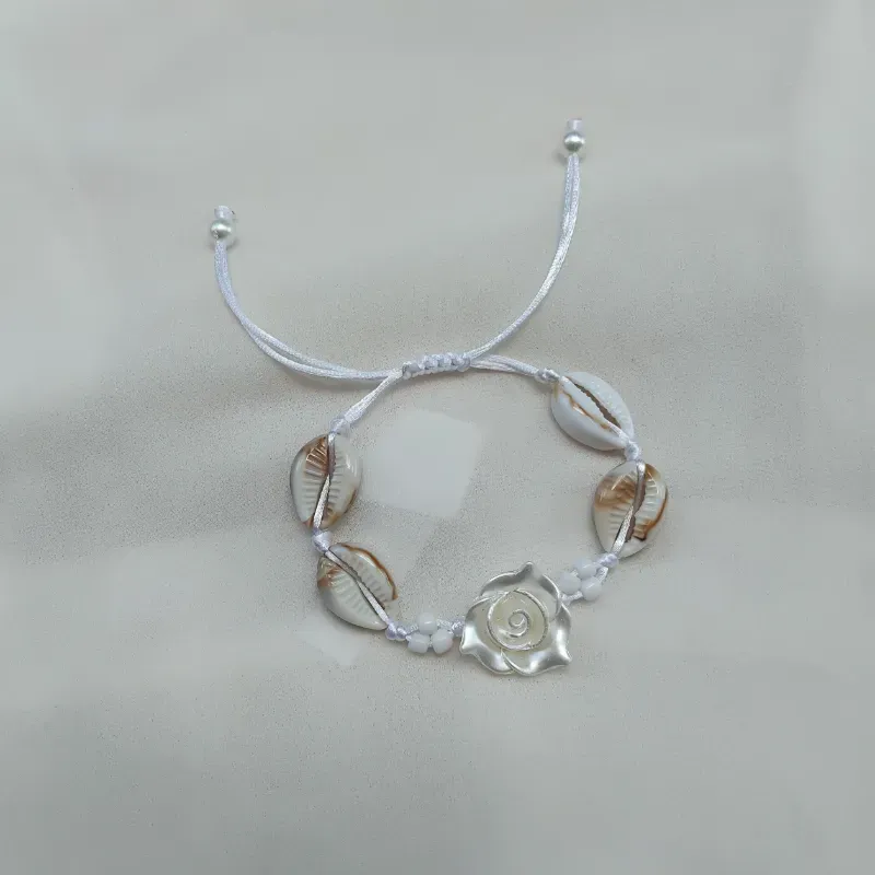 Pulsera de caracolas y flor blanca.
