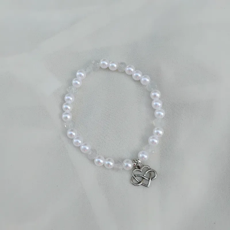 Pulsera de perlas blancas, swarovskis transparentes y dije.
