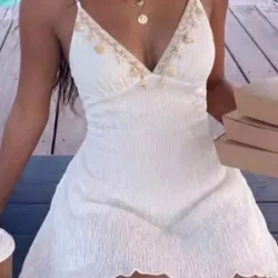 Vestido blanco con joyeria marina en el escote
