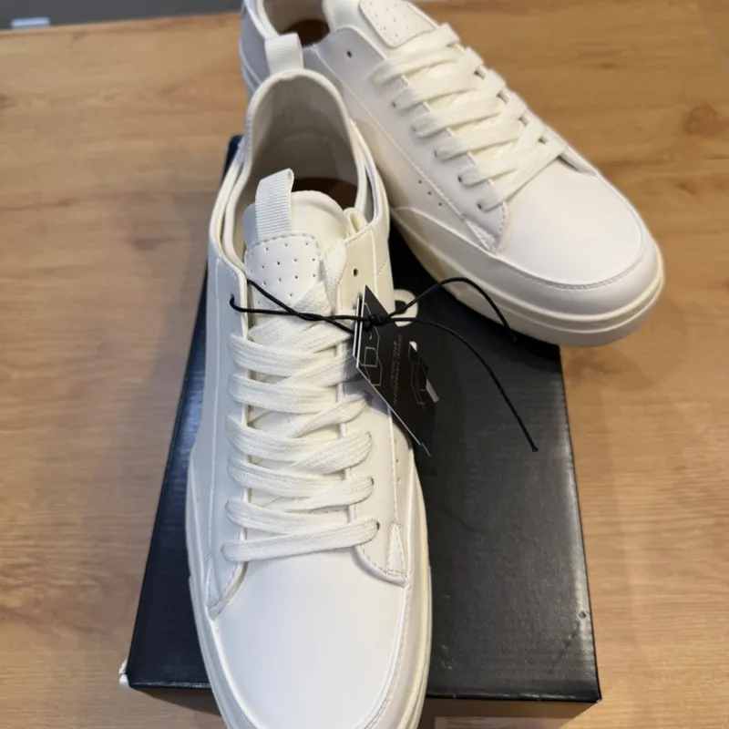 Tenis casuales blancos minimalistas.