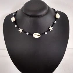 Collar de hilo negro tejido con caracoles y estrellas de mar 