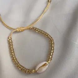 Pulsera de cuentas doradas con caracol