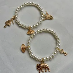 Pulseras de perlas con dijes dorados 