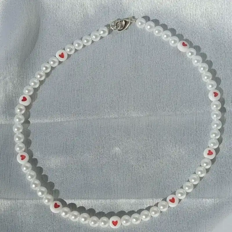 Collar de perlas con corazones rojos