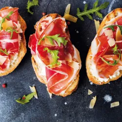 BRUSCHETTAS DE JAMÓN SERRANO, QUESO CREMA Y SALSA AGRIDULCE 