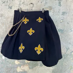Saya de tachones con flor de lis