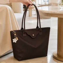 Cartera marrón con colgante de flor