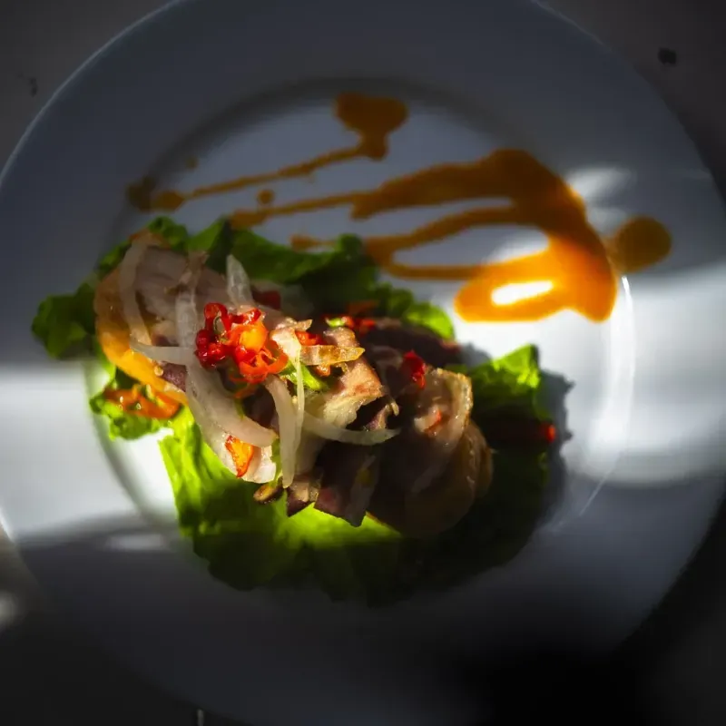 TAMAL CON CARNE, PIMIENTO, CEBOLLA Y BACON CRUJIENTE. 