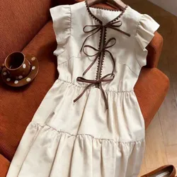 Vestido beige con lazos carmelitas