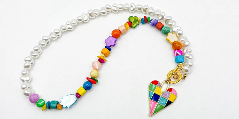 Collar con entrepiezas de nácar, perlas artificiales y dije esmaltado de acero inoxidable
