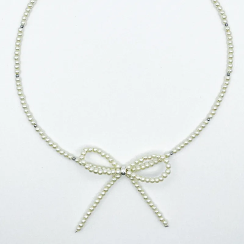 Collar de perlas con lazo con detalles en plateado 