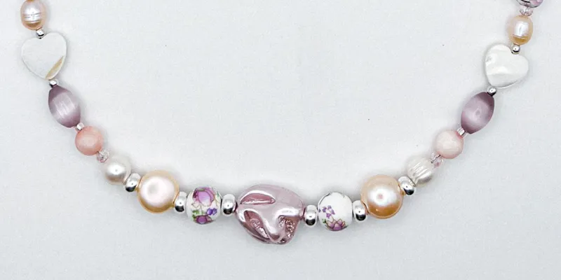 Collar de perlas naturales, artificiales, piedras semipreciosas, entre piezas de porcelana y cristales 