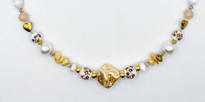 Collar de perlas naturales, artificiales, piedras semipreciosas, entre piezas de porcelana y cristales 