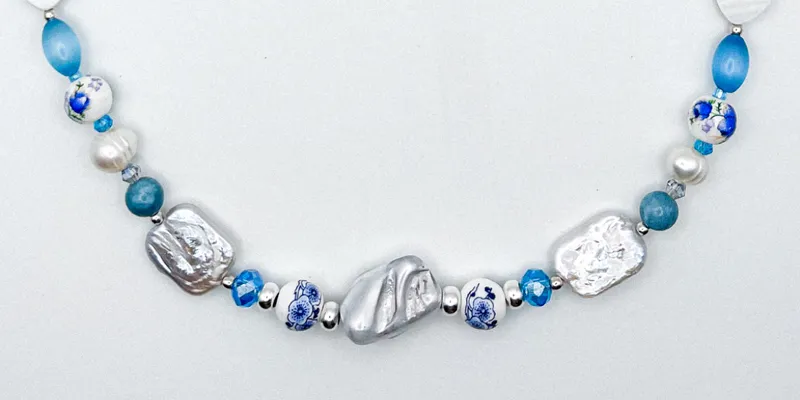 Collar de perlas naturales, artificiales, piedras semipreciosas, entre piezas de porcelana y cristales 