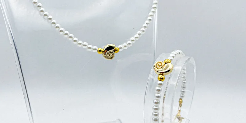 Conjunto de perlas artificiales y detalle de caracola