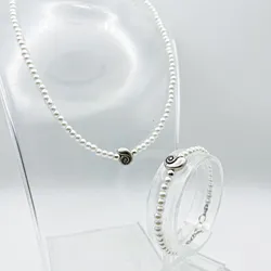 Conjunto de perlas artificiales y detalle de caracola