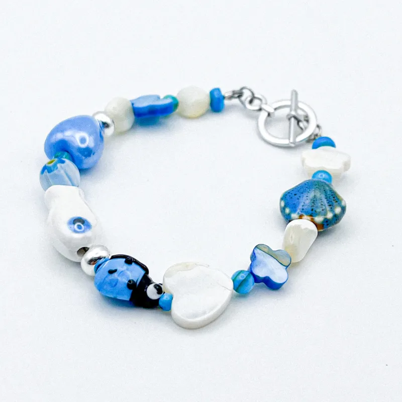 Pulsera con entrepiezas de nácar y cerámica vidriada 