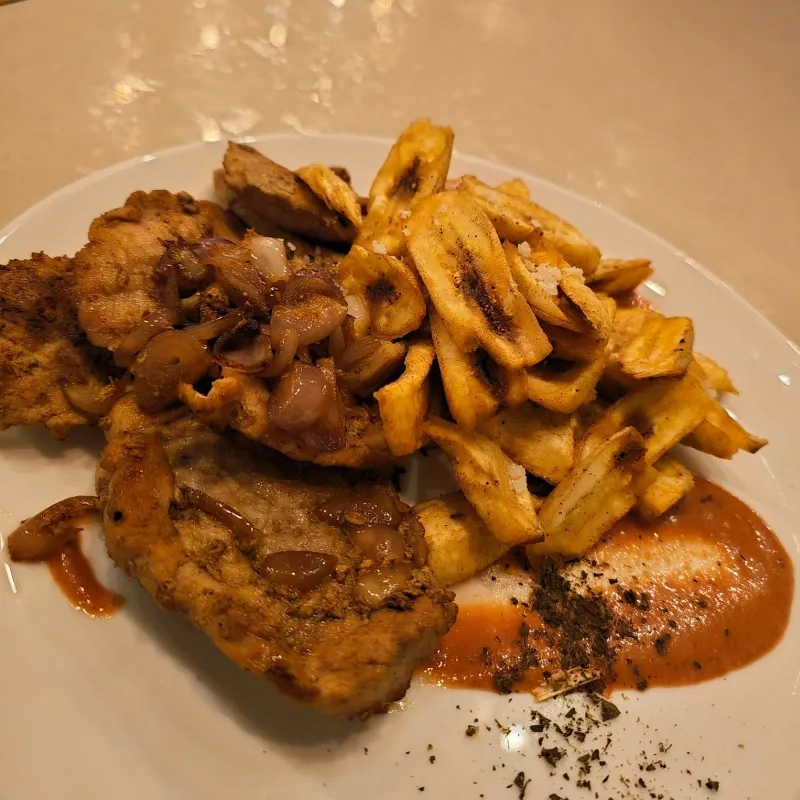 Bistec de cerdo con viandas fritas