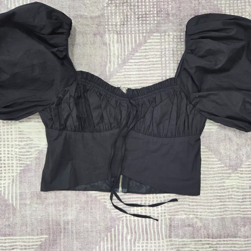 Blusa negra corta de mangas abullonadas 