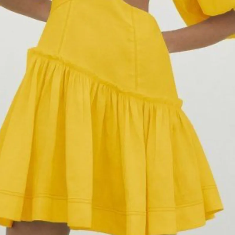 Vestido amarillo con mangas abullonadas y corte en la cintura