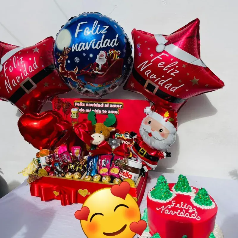Caja llena de confituras y chocolates con globos y peluche de navidad y pastel 