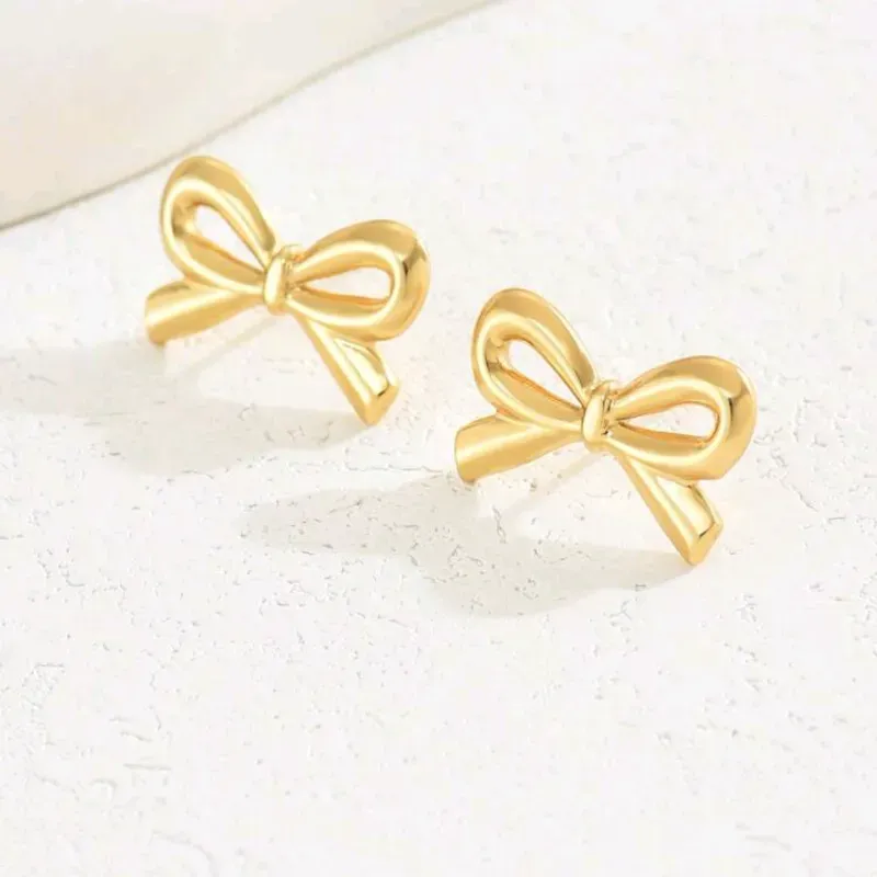 1 par de aretes de dama con forma de lazo clásico, lindos, simples y elegantes de acero inoxidable con baño de oro para uso diario